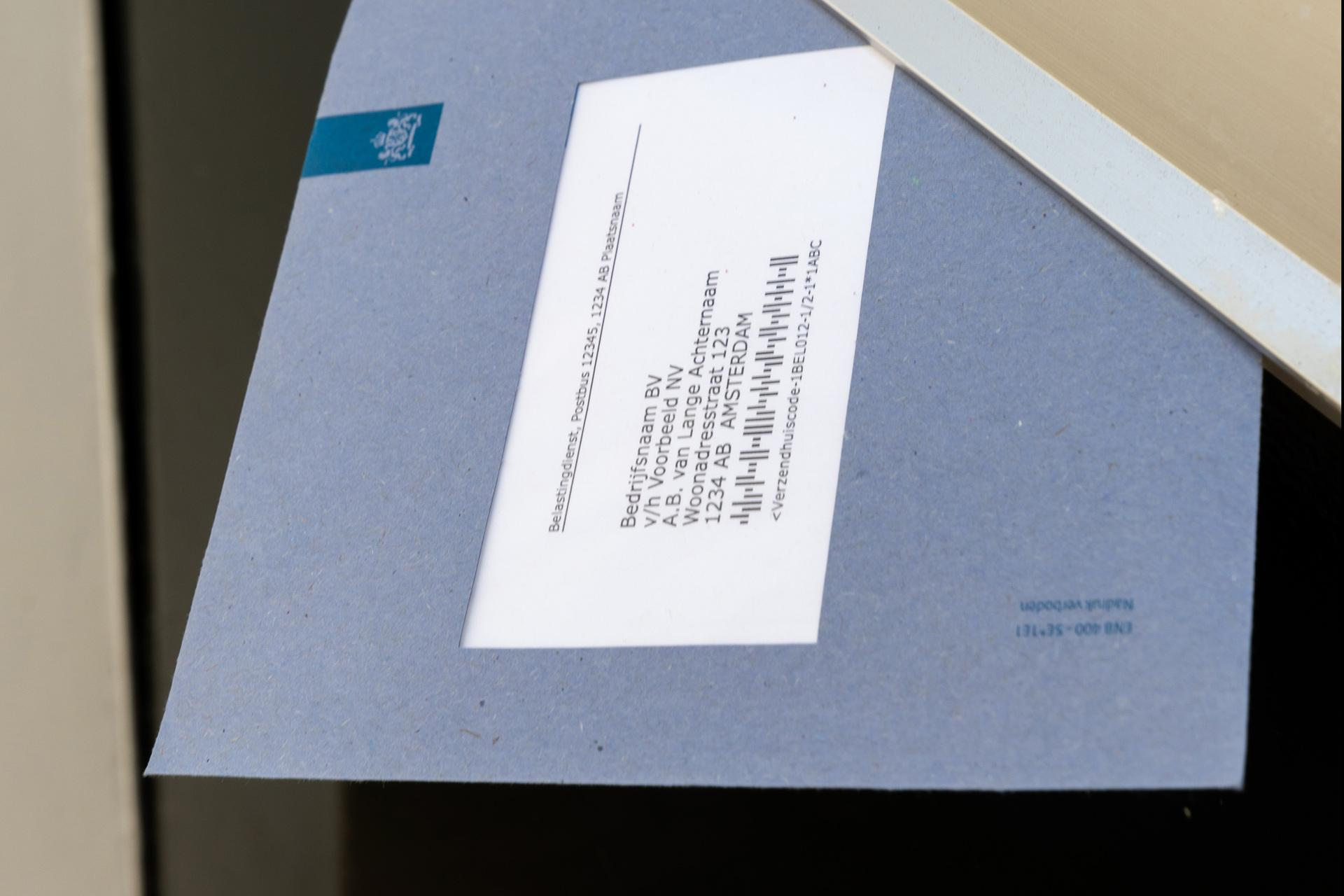 Blauwe envelop steekt uit een brievenbus.